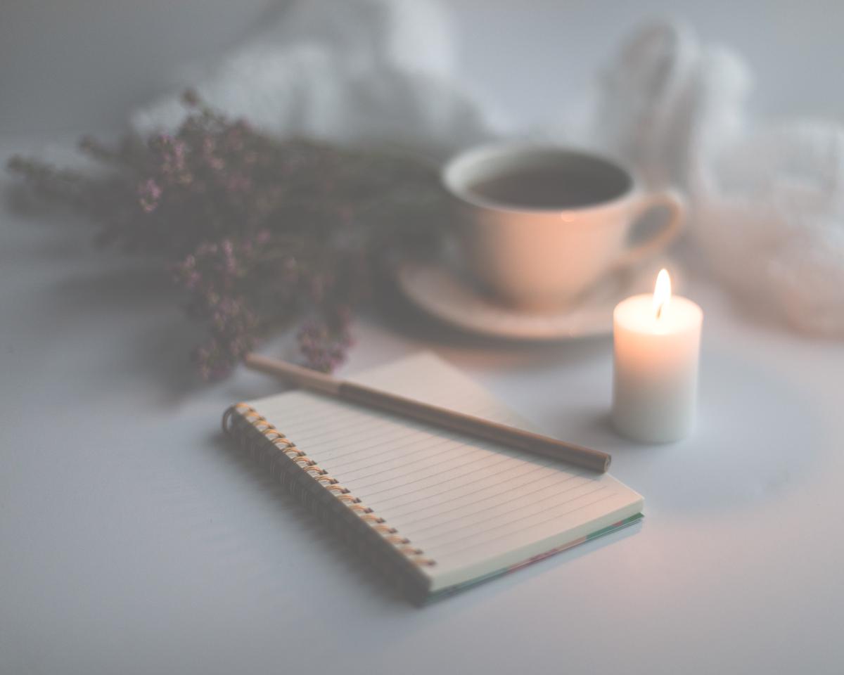 A person smiling and holding a gratitude journal, representing the concept of gratitude mindset